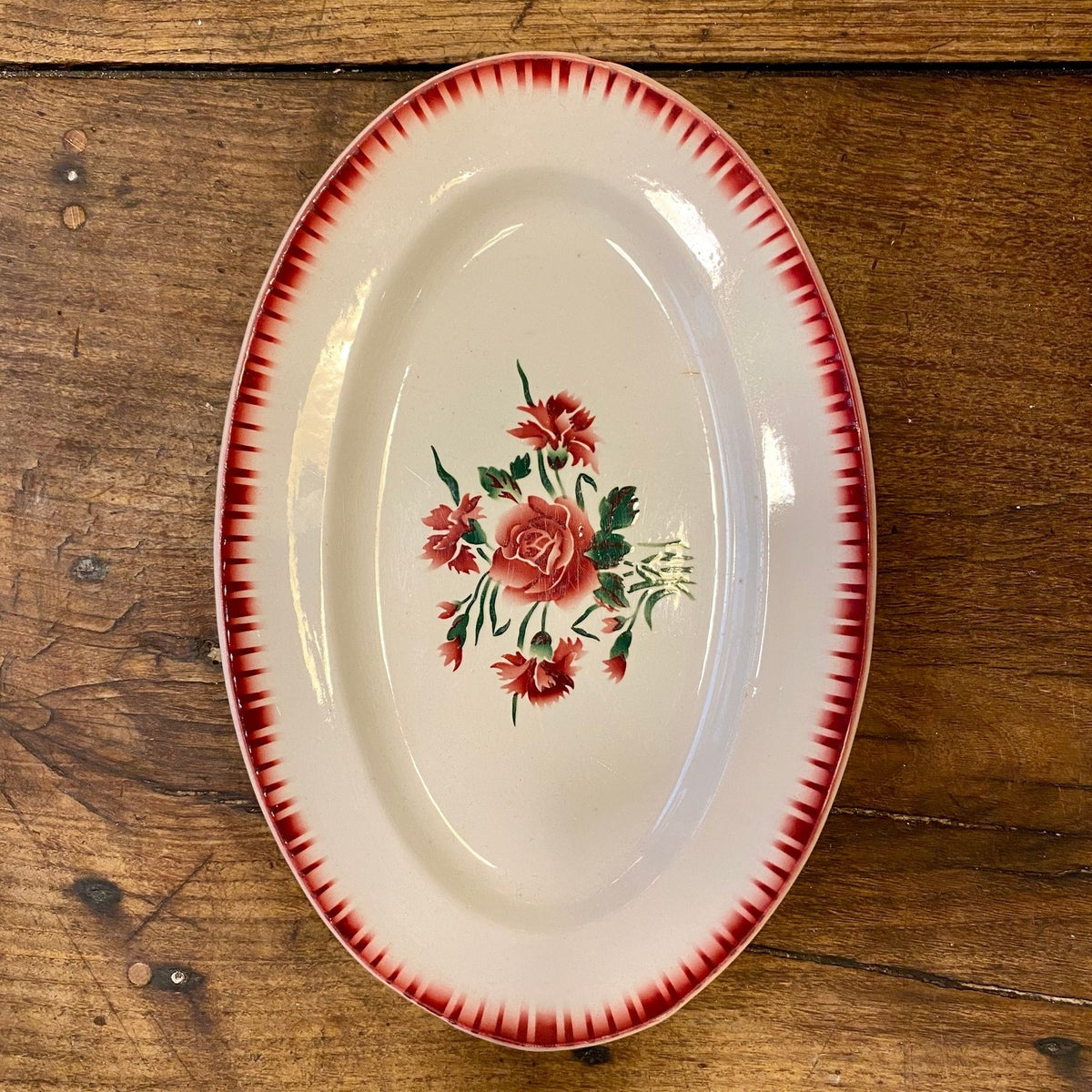 Vintage franskt ovalt Digoin Sarreguemines ‘Yvette’ serveringsfat med ros- och nejlikmotiv och röd bård i toning
