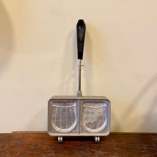 Croque monsieur iron with two ribbed moulds, seen from slightly above