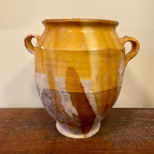 Confit pot seen from the side with the handle and the unglazed lower half