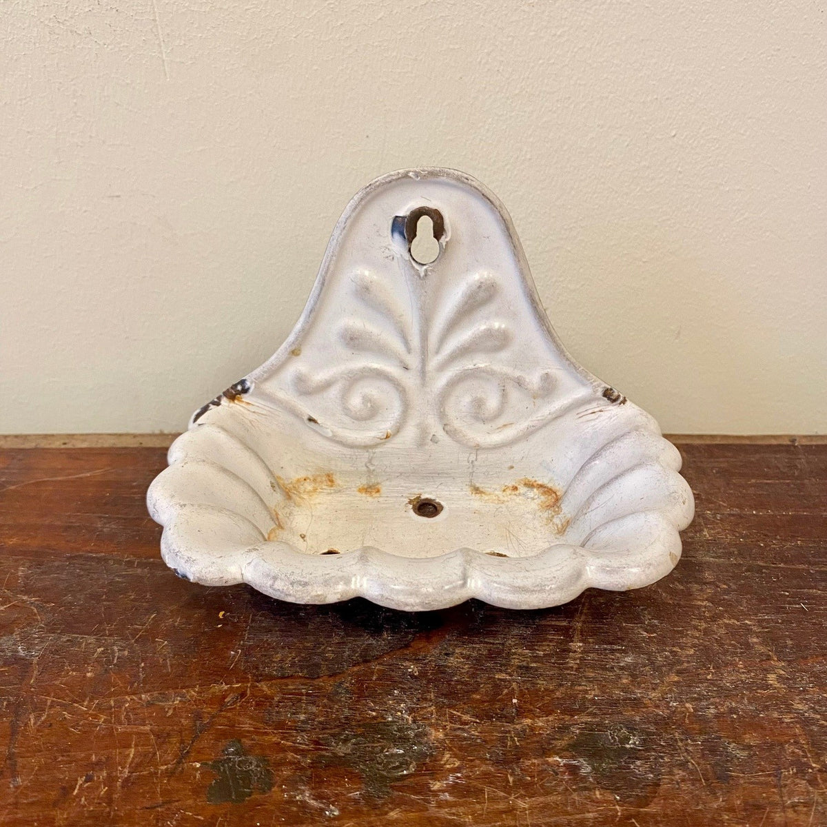 White enamel wall-mounted soap dish shaped as a scalloped shell, front view