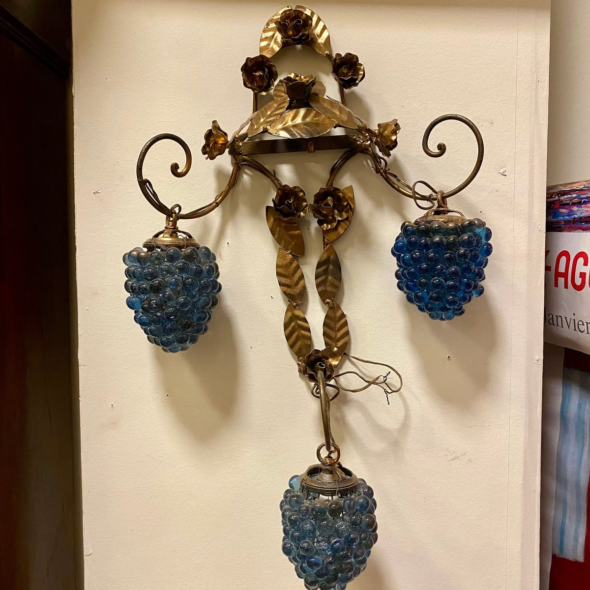 Antique wall light with gold-tone metal leaves and roses and three hanging blue glass grape clusters