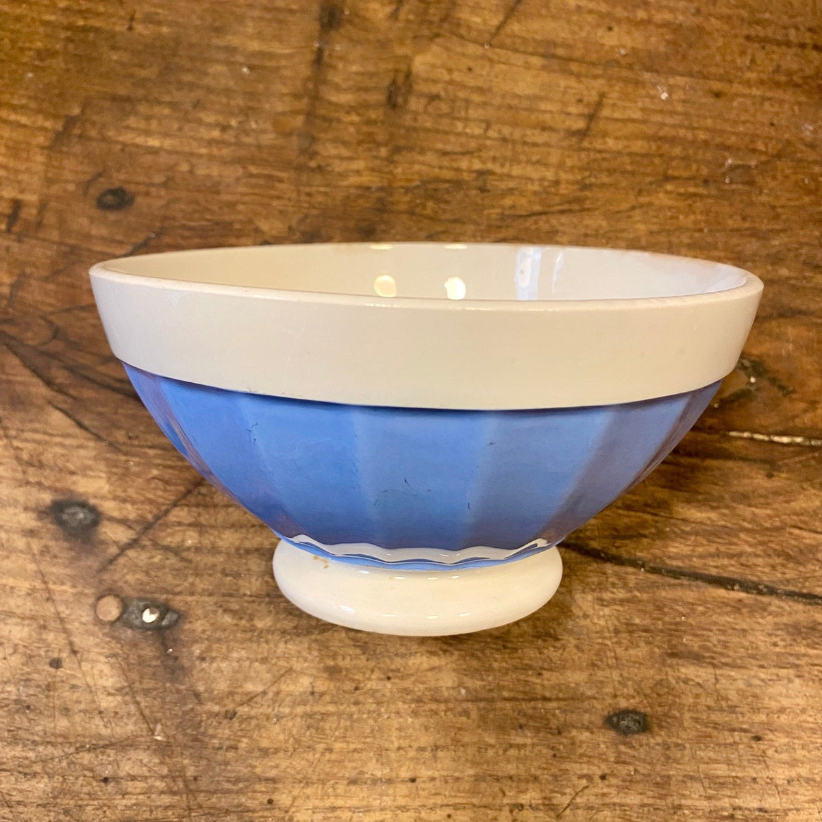 Vintage French Digoin café au lait bowl with ribbed blue sides and a white band at the rim, on a footed base