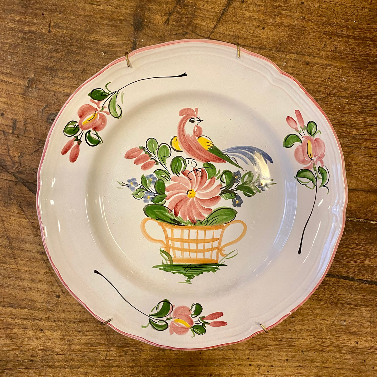 Vintage fransk väggtallrik med en handmålad tupp ovanför en blomsterkorg och en vågig kant kantad med rosa
