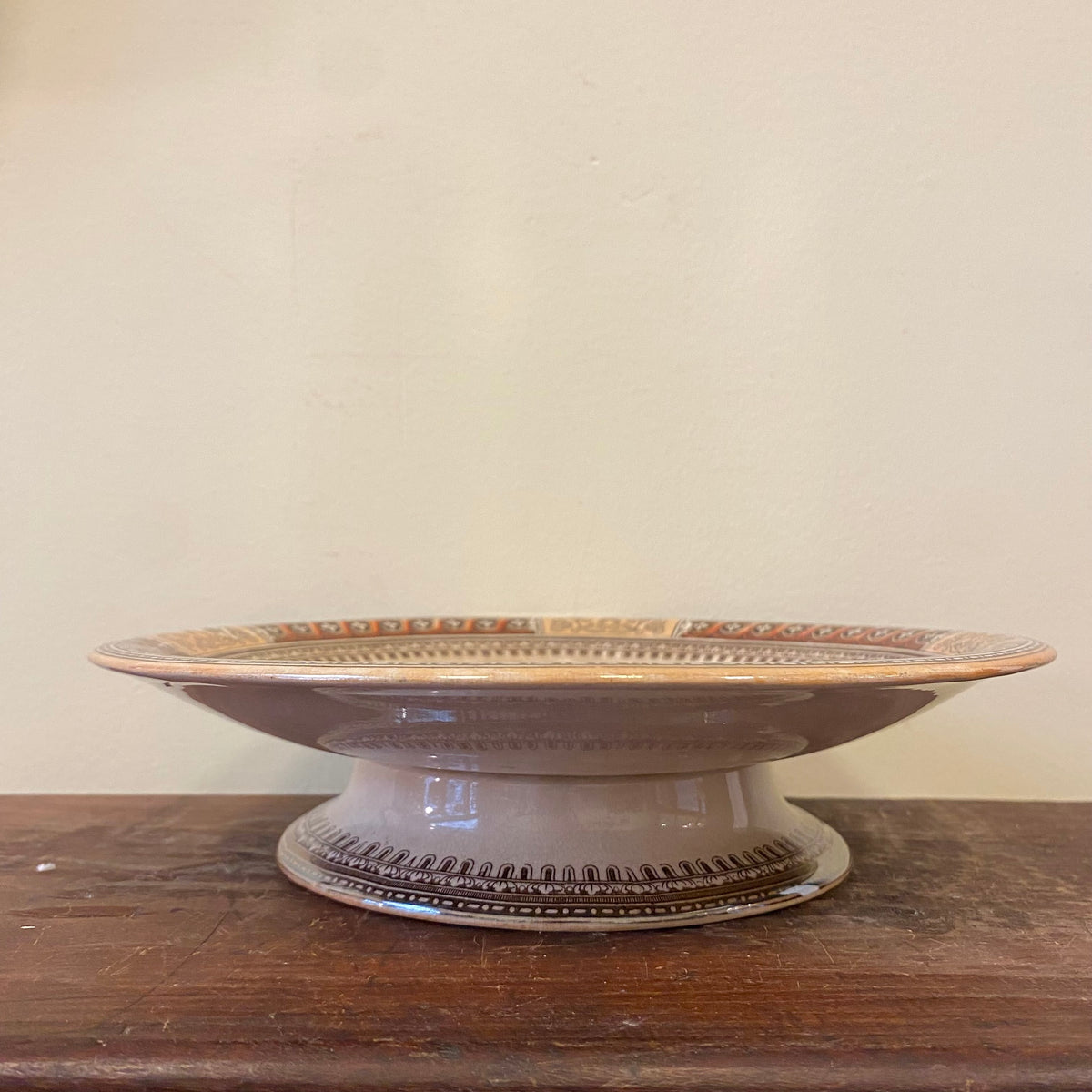 Side view of the pedestal dish showing the foot and the printed border