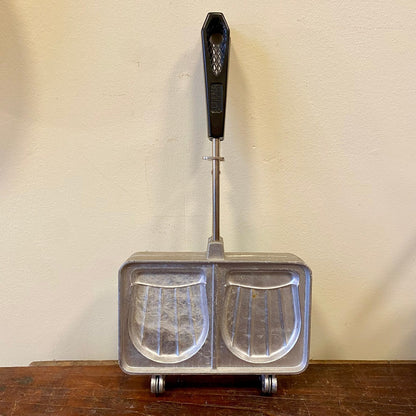 Vintage croque monsieur iron with two ribbed moulds, front view