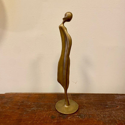 Abstrakt figur i mässing på rund bas, sidovy