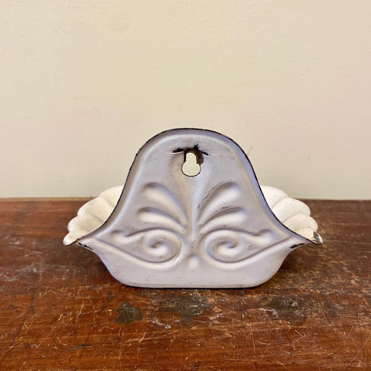 Back of the soap dish with the embossed palmette design and keyhole slot