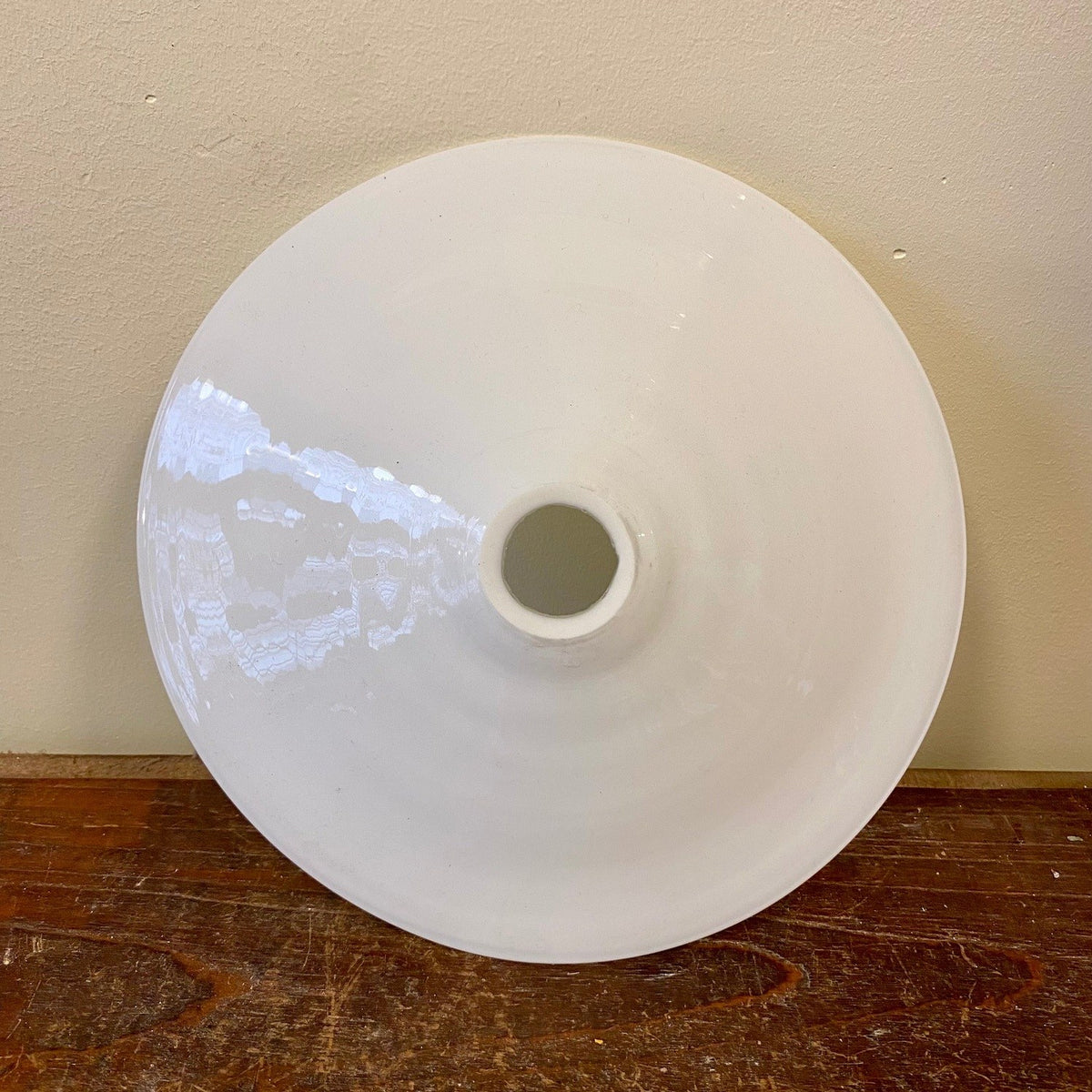 The lamp shade at a slight angle, showing the glossy white glass and the fitting opening