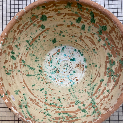 Close-up of the pale yellow glazed interior of the tian bowl with green splashes