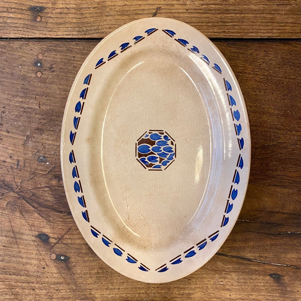 Vintage franskt ovalt Longchamp ‘Arlette’ serveringsfat med blå bladbård och en blå och brun åttakantig medaljong i mitten
