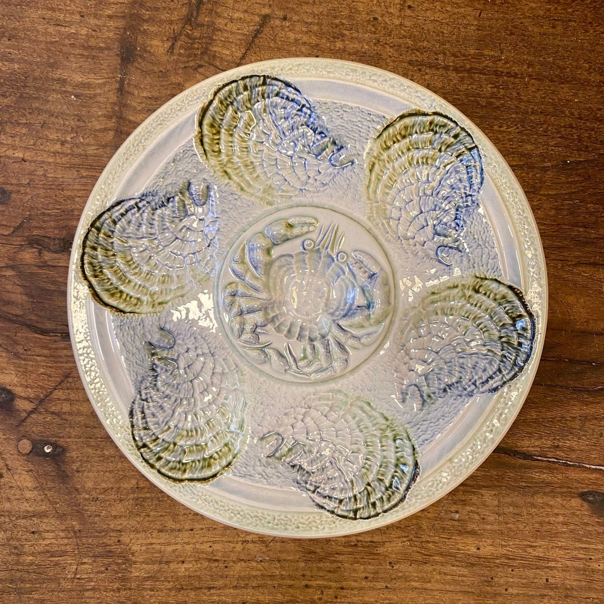 Vintage French Sarreguemines oyster plate in pale blue and green with six oyster-shaped wells around a central crab