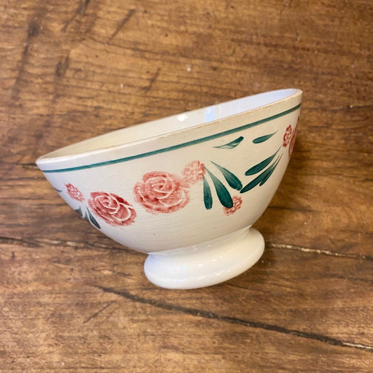 Vintage French St Amand café au lait bowl in off-white with pink roses and green leaves, on a footed base