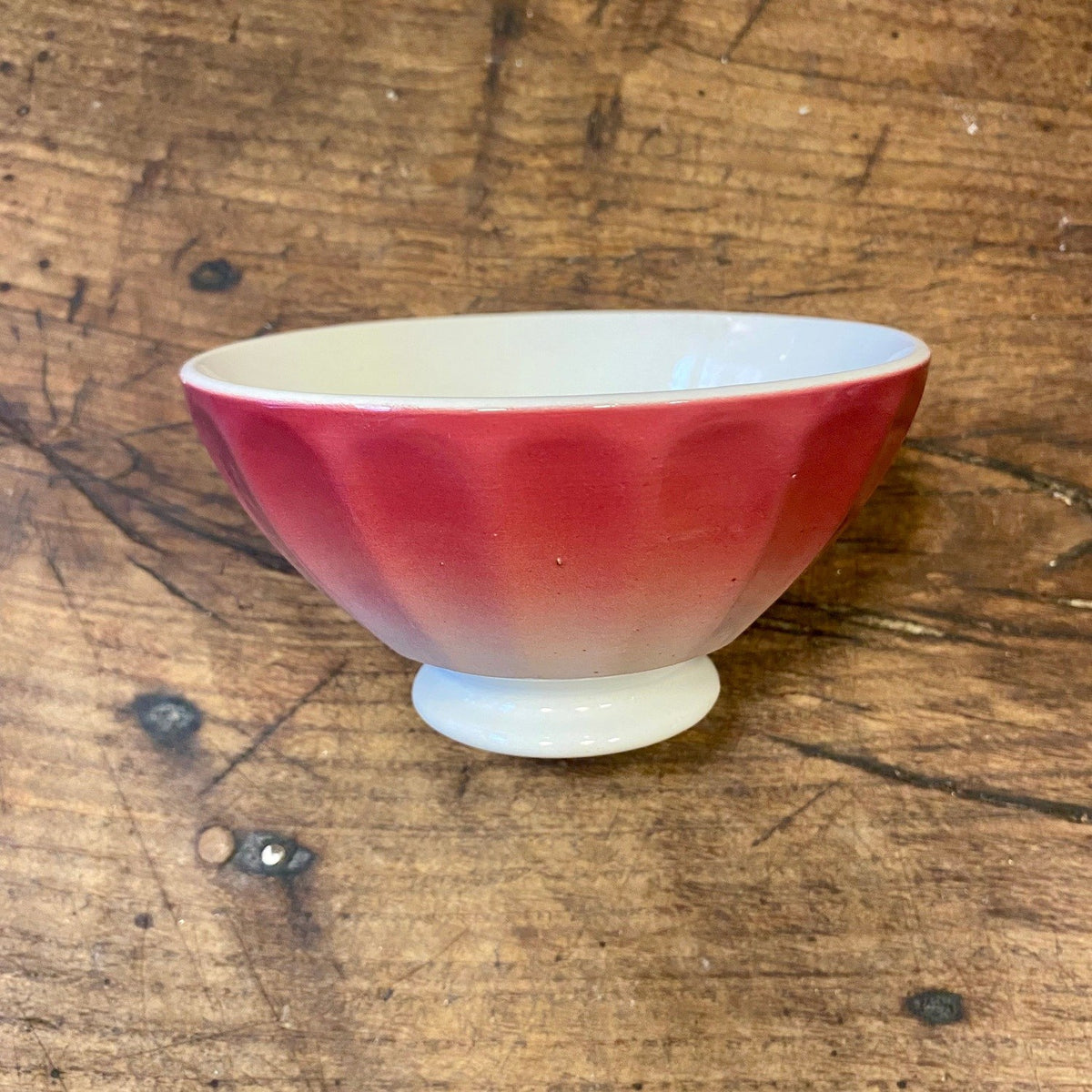 Vintage fransk café au lait-skål med räfflade sidor i rött som tonar till vitt, på fot