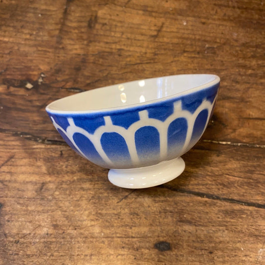 Vintage French café au lait bowl in blue with a pattern of white arches, on a footed base