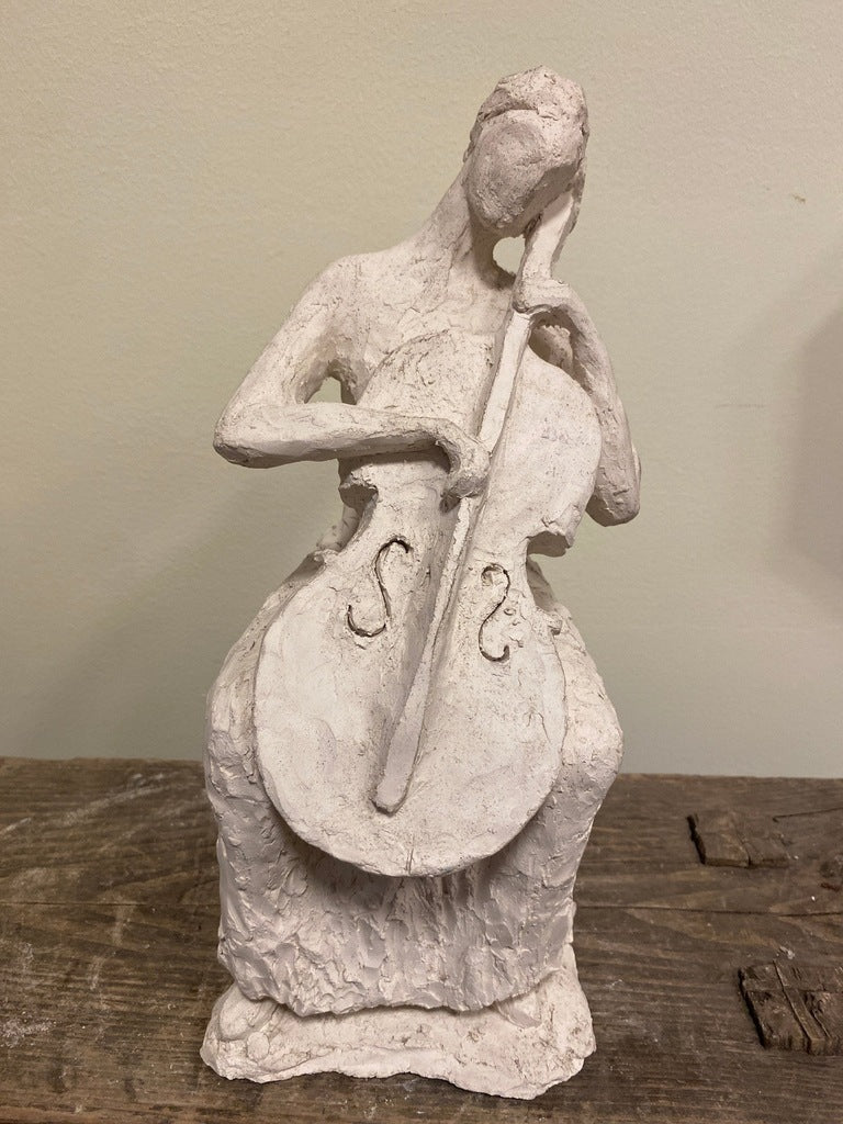 Vintage French sculpture of a seated figure playing a cello.